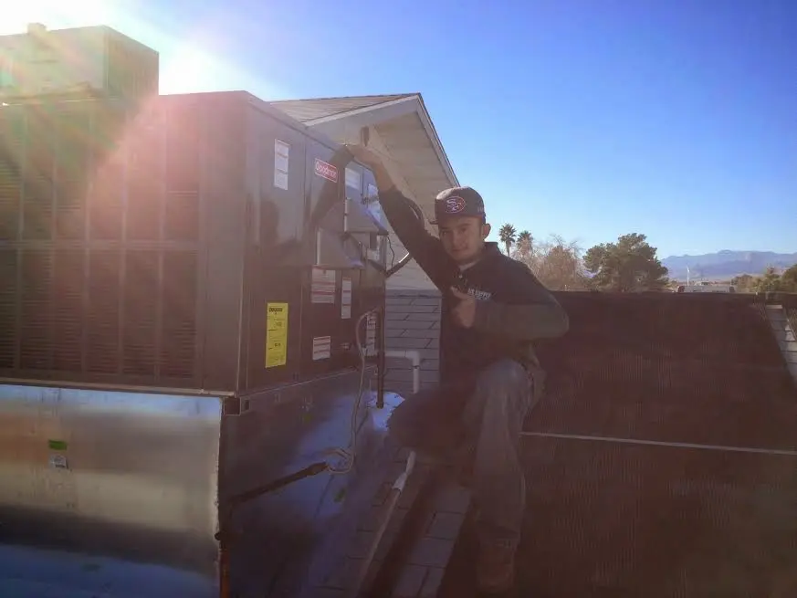 HVAC technician performing Heat Pump Repair on a rooftop unit in Owings Mills